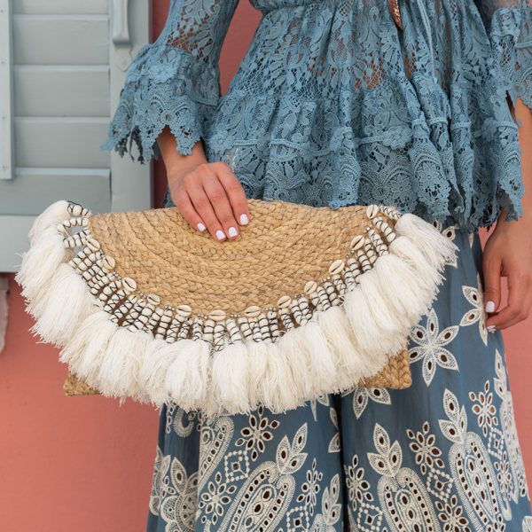 MAT HAND BAG IN A SEMI CIRCLE SHAPE EMBELLISHED WITH LARGE TASSELS AND SEASHELLS